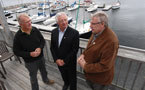 Environment Minister Sterling Belliveau stands on a balcony with Shelburne Mayor Alan Delaney and Shelburne Harbour Yacht Club commodore Allan Pulfrey.