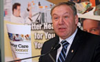 Premier Darrell Dexter holds a copy of the Better Care Sooner Plan while speaking to the audience in Middle Musquodoboit.